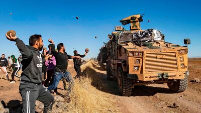 Kurdish demonstrators hurl rocks at a Turkish military vehicle on November 8, 2019, during a joint Turkish-Russian patrol near the town of Al Muabbadah in the north-east Hassakah. AFP