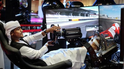 Rashed Alkalbani tests his driving skills in a racing simulator at the Elite Autosports stand at the International Motor Show Abu Dhabi and Custom Show Emirates at Abu Dhabi National Exhibition Centre. Delores Johnson / The National
