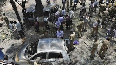 Police and forensic officials inspect the scene of a blast near the office of India's main opposition Bharatiya Janata Party (BJP) in Bangalore.