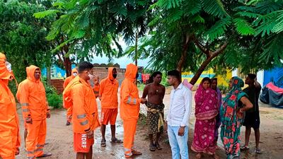 India's National Disaster Response Force personnel ask villagers to take precautions against Cyclone Gulab, that made landfall on Sunday evening at Ganjam. Photo: AP