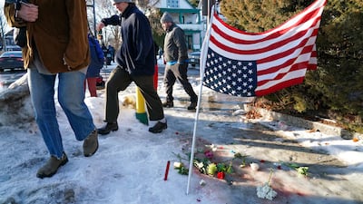 Flowers and an upside down US flag on the pavement. EPA