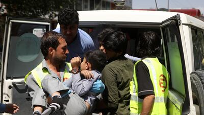 An Afghan health worker carries a wounded school student after a car bomb blast targeted a governmental institution in downtown Kabul. EPA