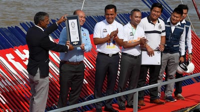 An adjudicator from Guinness World Records awards a certificate to Hun Many, lawmaker and son of Cambodian Prime Minister Hun Sen. AFP