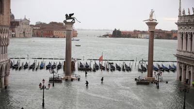 People make their way in a flooded St. Mark's Square in Venice, Italy. AP Photo