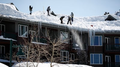 Residents shovel snow off a rooftop. EPA