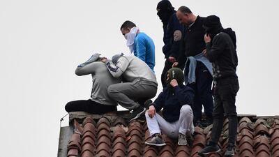 Inmates stage a protest on a rooftop of a wing at the San Vittore prison in Milan. AFP