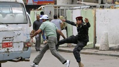 A policeman fights with a man as he tries to arrest him during a protest in Baghdad on April 22. Iraqis protested in Tahrir Square demanding the withdrawal of the American forces from Iraq and an end to rampant corruption. Police allege that the man was a thief.