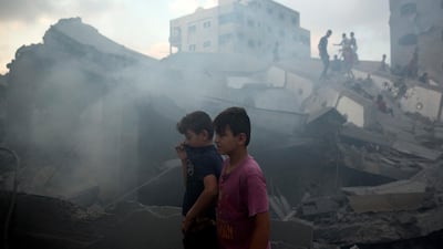 Palestinian children inspect damaged buildings in Gaza City on Thursday. AP Photo