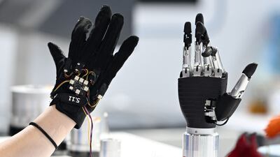 A staff member remotely controls a bionic arm using force-sensing gloves at the 2025 World Semiconductor Conference and Expo in Nanjing, in China’s eastern Jiangsu province. AFP