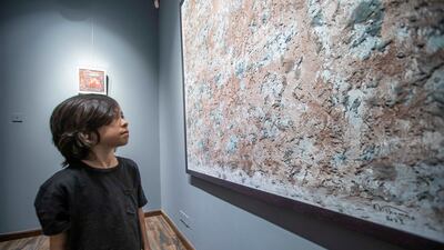 Sammy Mohammed Al Kairo, a six-year-old boy from Iraq, looking at his 'favourite painting' in the exhibition