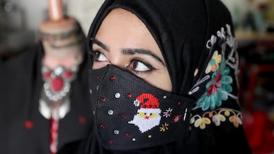 A Palestinian woman wears a face mask with Santa Claus during Christmas celebrations according to the Eastern Orthodox calendar, amid the outbreak of the coronavirus disease (COVID-19), in Gaza City. Reuters