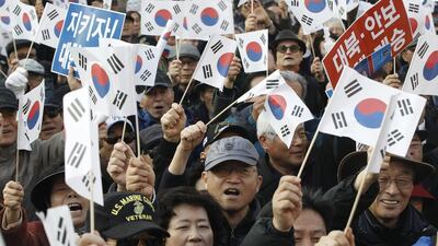 Protesters supporting South Korean president Park Geun-hye wave national flags during a rally opposing her resignation in Seoul, South Korea on November 17, 2016. Ahn Young-joon/AP Photo