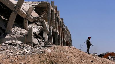 A member of Syrian forces of President Bashar Al Assad stands guard near destroyed buildings in Jobar, eastern Ghouta. Reuters