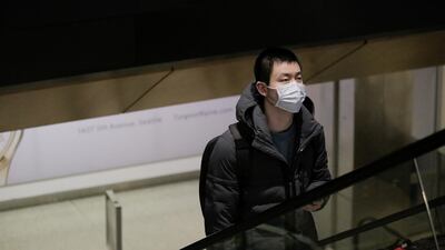 A traveller wearing a mask arrives in Seattle on a direct flight from China. Reuters