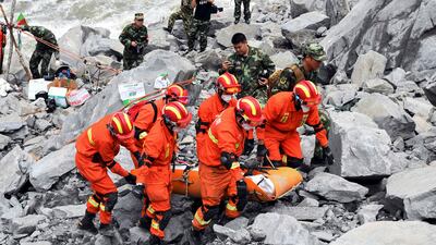 Rescue workers evacuate a body from the site of a landslide in the village of Xinmo, Mao County, Sichuan Province, China June 25, 2017. CNS/An Yuan via REUTERS ATTENTION EDITORS - THIS IMAGE WAS PROVIDED BY A THIRD PARTY. CHINA OUT. NO COMMERCIAL OR EDITORIAL SALES IN CHINA.