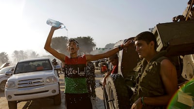A rebel fighter pours water on his head inside Moammar Gadhafi's compound in Bab Al-Aziziya in Tripoli, Libya, Tuesday, Aug. 23, 2011. Libyan rebels stormed Moammar Gadhafi's main military compound in Tripoli Tuesday after fierce fighting with forces loy???
