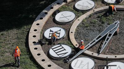 Communal workers clean a giant clock in downtown Kiev, Ukraine. EPA