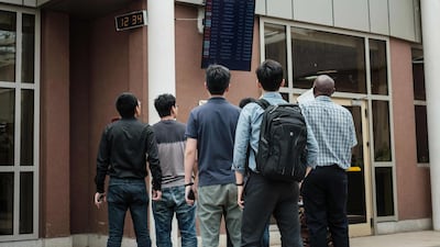 A Chinese group look at the arrival schedule board at the Jomo Kenyatta International Airport in Nairobi, Kenya. AFP