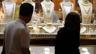 Shoppers look to buy gold at the Gold Souq in Dubai. Spot gold has hit record highs and gained nearly 21 per cent so far this year. Chris Whiteoak / The National