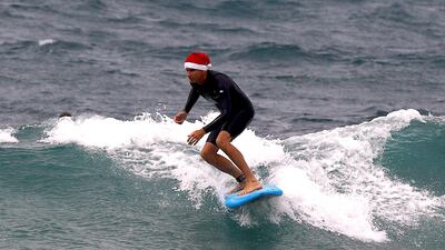 A surfer wearing a Christmas hat rides a wave on his surfboard on Christmas Day at Sydney's Bondi Beach in Australia on December 25, 2017. David Gray / Reuters