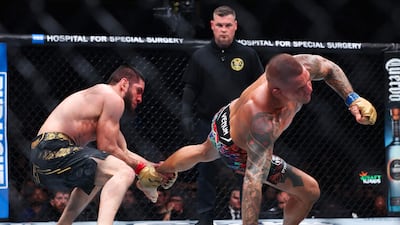 Islam Makhachev grabs hold of Dustin Poirier's leg during their lightweight title bout at UFC 302. AFP