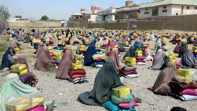 Afghan burqa clad women sit after they received ration aid in Kandahar, Afghanistan. Muhammad Sadiq / EPA