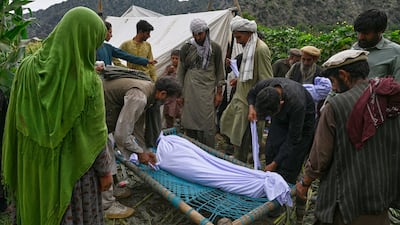 The body of a girl is placed on a bed frame after being pulled from the rubble. AP