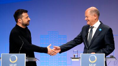 Ukrainian President Volodymyr Zelenskyy, left, and German Chancellor Olaf Scholz shake hands after a press conference at the event in Berlin on Tuesday. AP