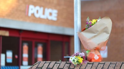 Flowers are left outside the Henderson Police station in Auckland, New Zealand. A police officer has died and another is injured following a shooting during a traffic stop in the Auckland suburb of Massey. Getty Images