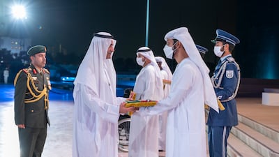 Sheikh Hamad bin Mohammed Al Sharqi, Ruler of Fujairah, presents a medal to a relative of a UAE hero who died this year, at Wahat Al Karama. Photo: Mohamed Al Hammadi / Ministry of Presidential Affairs