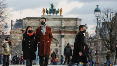 People wearing protective face masks walk in the Tuileries Gardens in Paris as infections soar to record levels. Reuters
