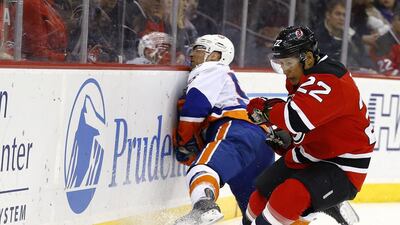 New York Islanders defenceman Johnny Boychuk, left, slams onto the boards as New Jersey Devils right wing Jordin Tootoo defends during the second period of an NHL hockey game, in Newark, New Jersey. Julio Cortez / AP photo