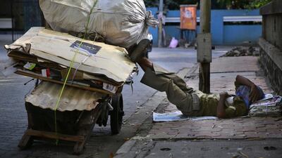 A migrant laborer sleeps on a pavement next his handcart in Mumbai. Rafiq Maqbool / AP Photo
