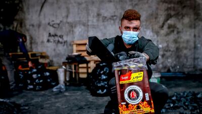 A worker fills bags of charcoal. AFP