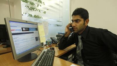 Ahmed Raza, in his Dubai office, keeps track of the latest score of the Afghanistan-Kenya game. Satish Kumar / The National