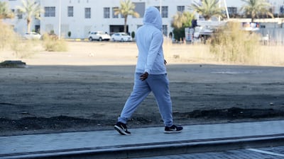 People wear warm clothes during a cold morning in Dubai. Pawan Singh / The National
