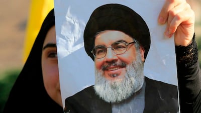 A supporter of Hezbollah holds a poster bearing a picture of its leader Hasan Nasrallah. AFP