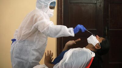 A woman in personal protective equipment (PPE) collects a swab sample from a woman amidst the spread of the coronavirus disease (Covid-19) in Mumbai, India, September 12, 2020. Reuters