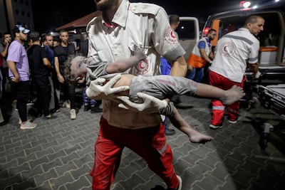 A Palestine Red Crescent Society (PRCS) members carries a wounded child at Al Shifa hospital in Gaza City, on October 9, 2023. EPA
