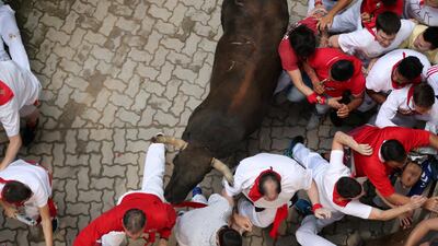 Revellers sprint in front of a bull during the seventh running of the bulls of the San Fermin festival. Reuters