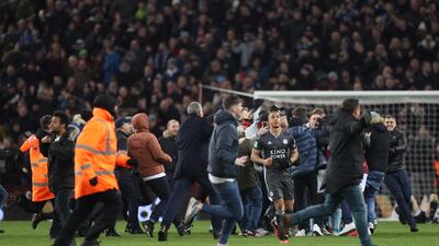 Aston Villa players celebrate with fans on the pitch. Reuters