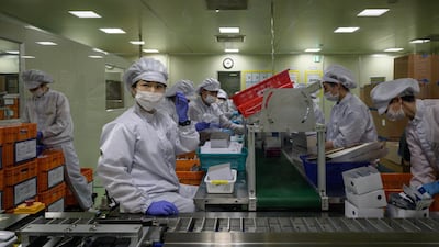 Staff members restock a machine with components used in testing for Covid-19 novel coronavirus. AFP