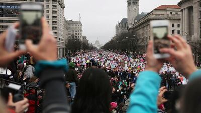 Women take photos as protesters walk during the Women’s March on Washington. Mario Tama / Getty Images / AFP