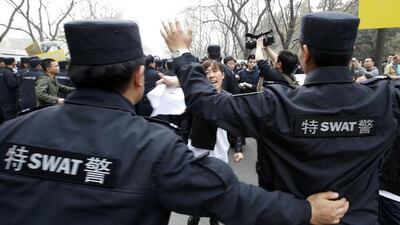 A family member of a passenger onboard Malaysia Airlines Flight MH370 shouts as policemen attempt to prevent them from marching down a street during a protest, near Lido Hotel in Beijing. Kim Kyung-Hoon / Reuters