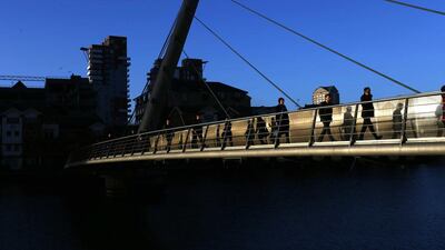 Workers walk across a footbridge towards the Canary Wharf business district in London. London’s financial services sector created 25 per cent more jobs in February than a year ago, new data has shown, indicating the industry may be recovering. Eddie Keogh / Reuters