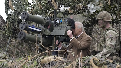 Britain's King Charles III takes a closer look at a lightweight multiple launcher, during a visit to military barracks on Thorney Island. Reuters