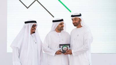 Sheikh Mohamed bin Zayed presents an award for Naji Hasan Al Harthi (centre), for participating in Sandooq Al Watan, during a Sea Palace barza. They are seen with Lt General Dhahi Khalfan Tamim, Chairman of the Board of Directors at Sandooq Al Watan (left). Rashed Al Mansoori / Ministry of Presidential Affairs