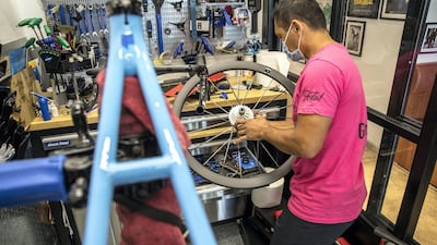 A mechanic assembles the components of a custom bicycle, with the parts having been shipped from Europe.