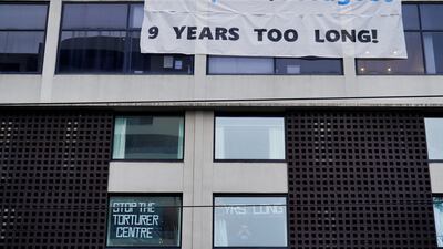 A man gestures in a window of the Park Hotel, where Serbian tennis player Novak Djokovic is believed to be held in Melbourne. Reuters