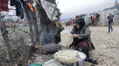 A Syrian woman baking bread outside at a refugee camp on the outskirts of the town of Zahle in Lebanon's Bekaa Valley. Joseph Eid / AFP